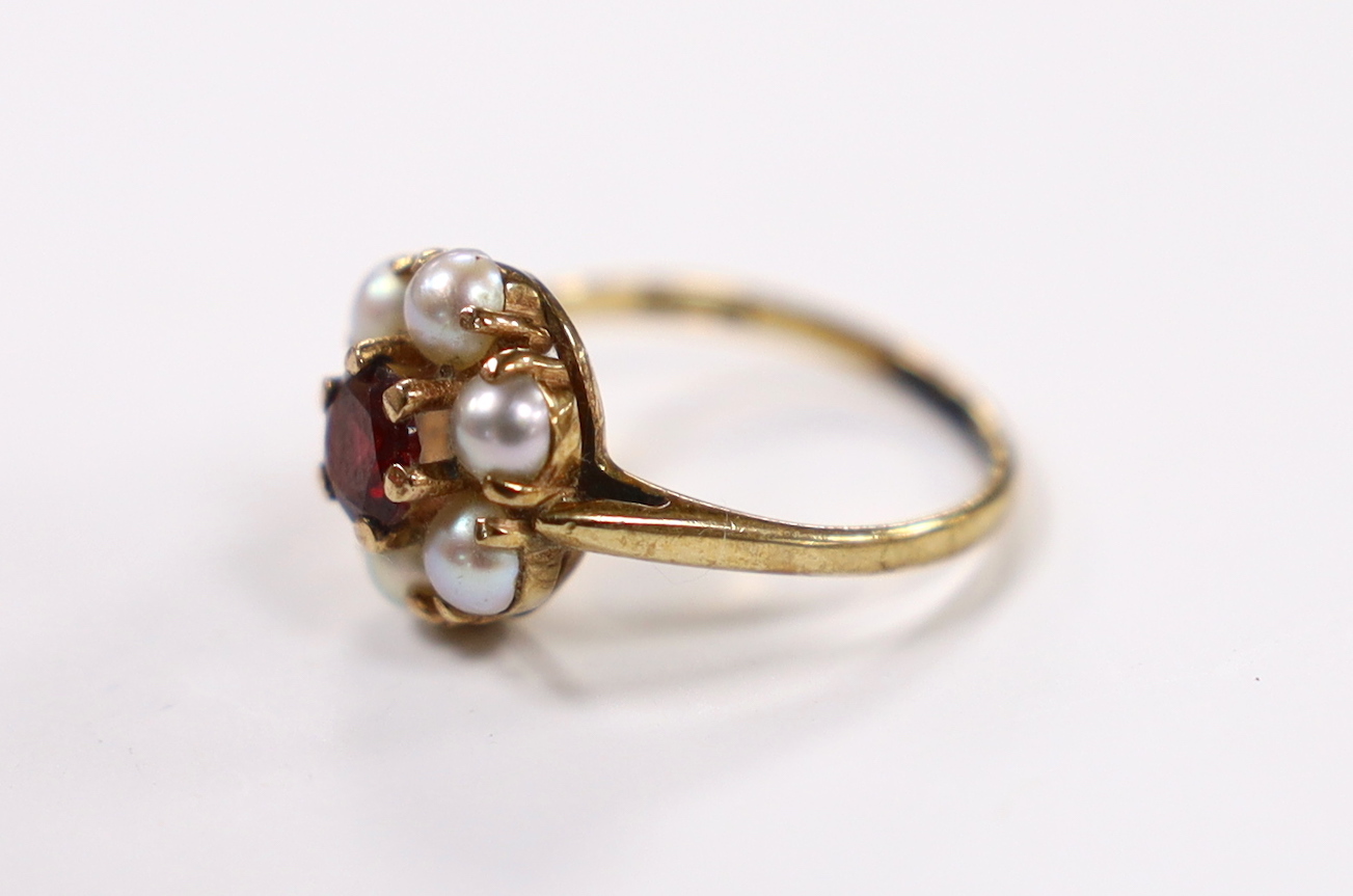 A 9ct gold, garnet and seed pearl cluster set flower head ring, size I, gross weight 2.4 grams.